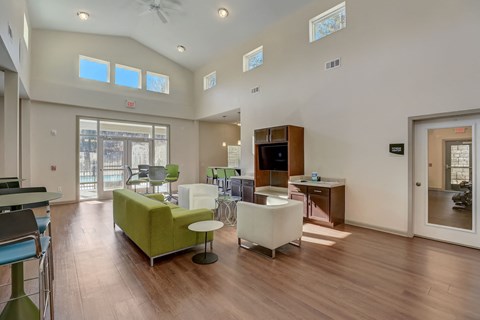a living room with couches and chairs and a kitchen with a door